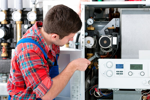 Heating technician repairing boiler controls in Union City
