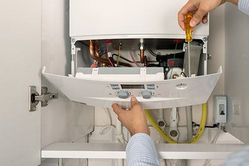 Heating technician repairing a residential boiler in Union City