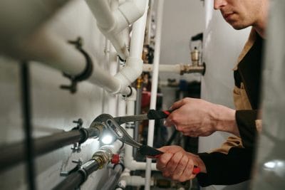Technician inspecting commercial plumbing pipes in Union City