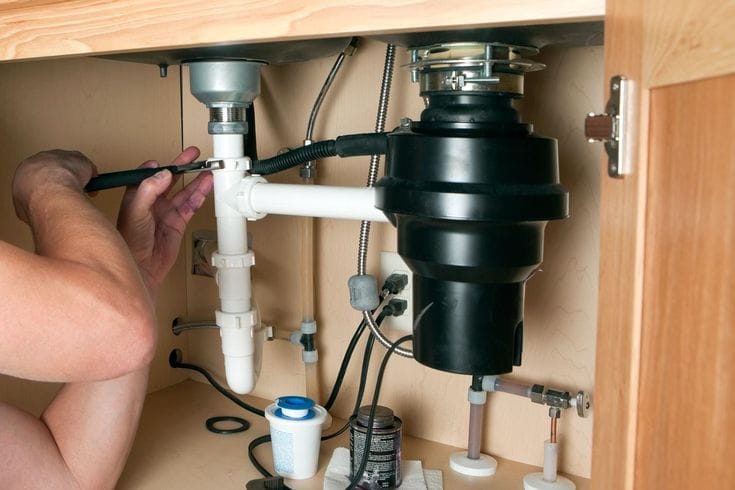 Plumber repairing a garbage disposal in Union City