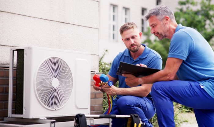 HVAC technicians installing an outdoor air conditioning unit in Union City